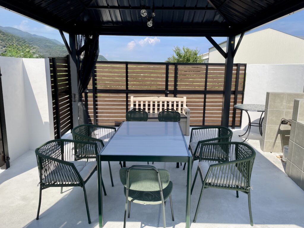 ガゼボ、キッチン、ダイニングテーブルセットのあるBBQスペース